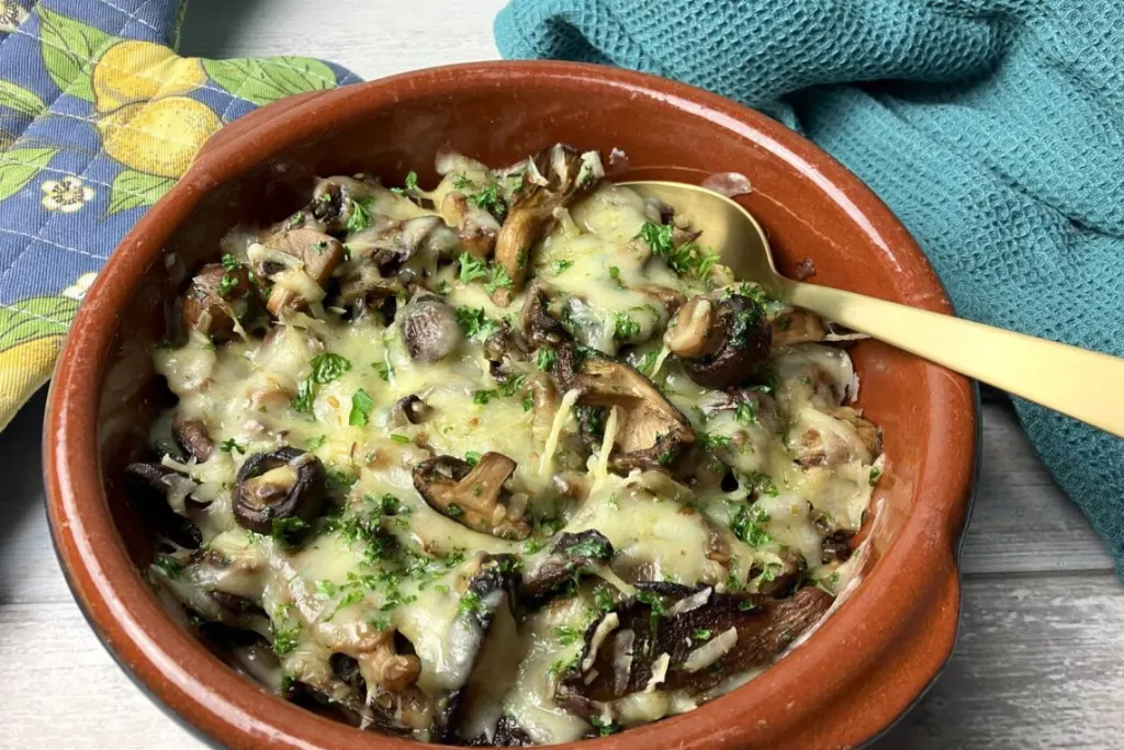 Gegratineerde knoflook champignons met biologische kaas.